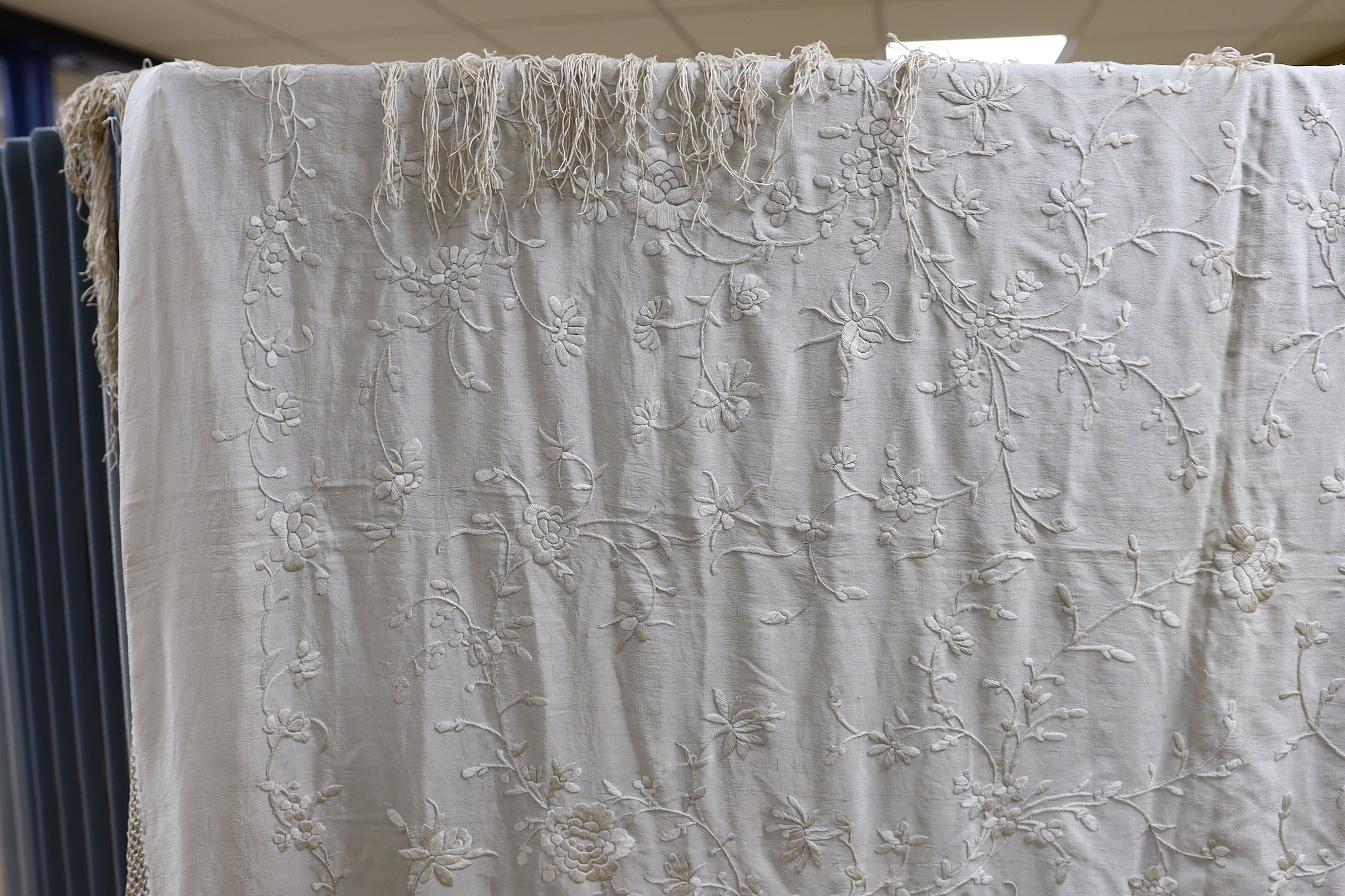 A Chinese late 19th century silk embroidered shawl, with cream on cream embroidery and a cream silk fringe, 140x134 cms